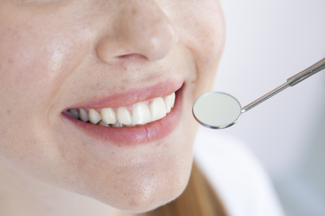 歯科治療を受けて、笑みを浮かべる女性